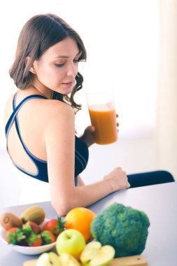 Resepsiyon ile meyve ve meyve suyu ile gözlük mutfakta oturan kız.