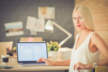 Moda tasarımcıları stüdyoda çalışıyor. Masanın üzerinde oturuyorlar..