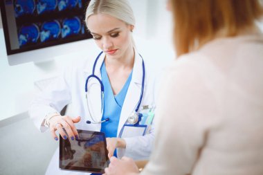 Doktor ve hasta masada otururken bir şey tartışıyorlar. Tıp ve sağlık hizmetleri kavramı. Doktor ve hasta.