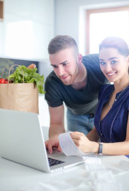 Çift evde mutfak içinde laptop ile onların fatura ödeme