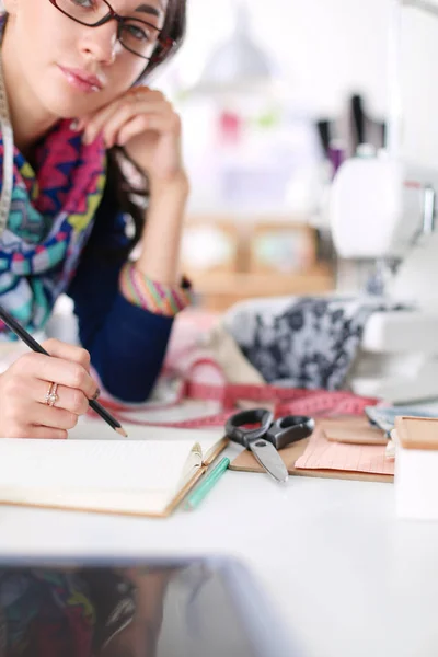 Young dressmaker designing clothes pattern on paper . — Stock Photo, Image