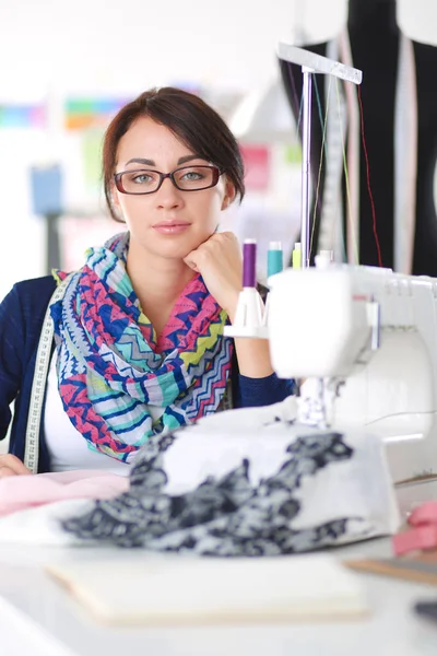 Mladá žena šití při sezení na svém pracovišti . — Stock fotografie