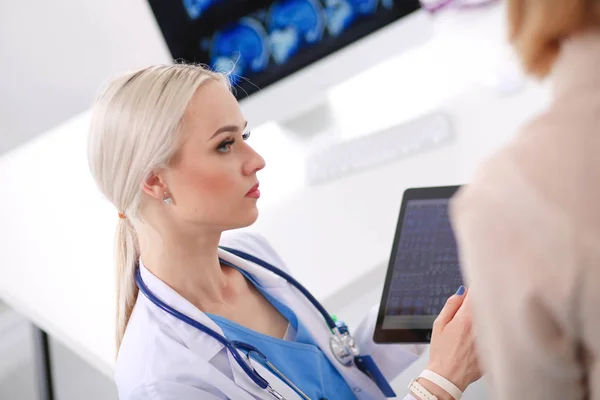 Doktorn och patienten diskuterar något när de sitter vid bordet. Medicin och hälsovård koncept. Läkare och patient — Stockfoto