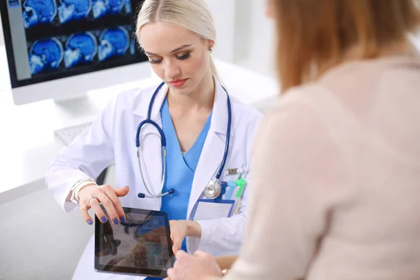 Doktorn och patienten diskuterar något när de sitter vid bordet. Medicin och hälsovård koncept. Läkare och patient — Stockfoto