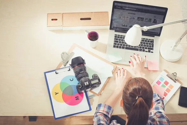 Female photographer sitting on the desk with laptop . Female photographer — Stock Photo, Image