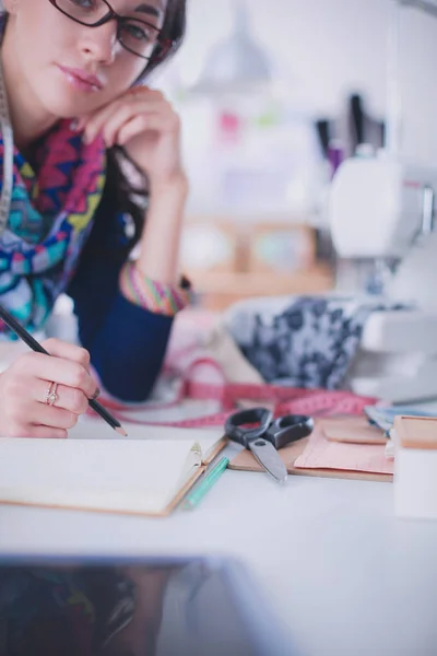 Jeune couturière concevant des vêtements sur papier . — Photo