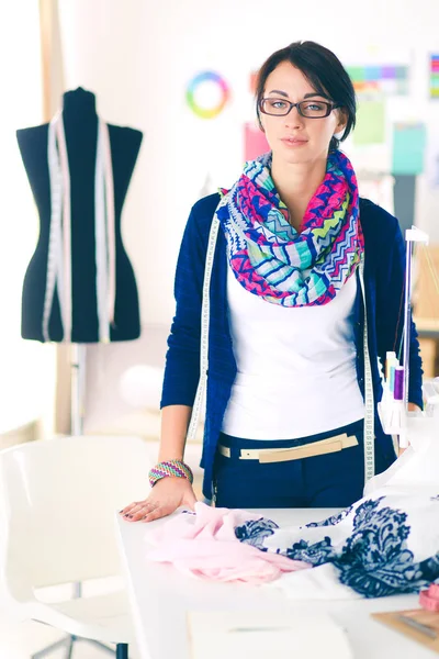 Schöne Modedesignerin steht im Atelier . — Stockfoto