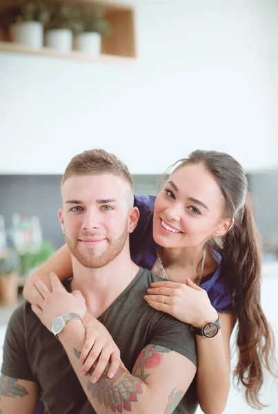 Belo jovem casal está se divertindo na cozinha em casa — Fotografia de Stock