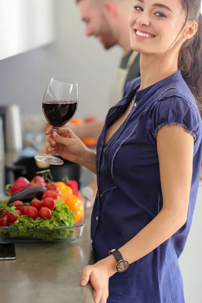 Casal beber vinho enquanto cozinha na cozinha — Fotografia de Stock