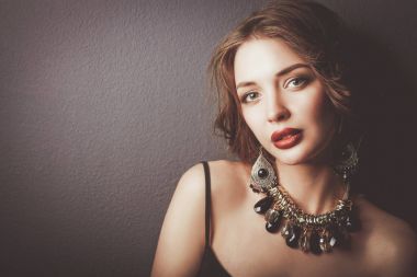 Siyah elbiseli, akşam makyajlı güzel bir kadın.