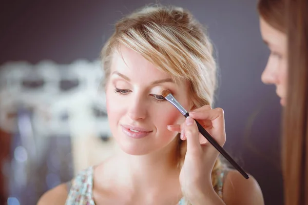 Kunstenaar doet professionele make-up van vrouw — Stockfoto