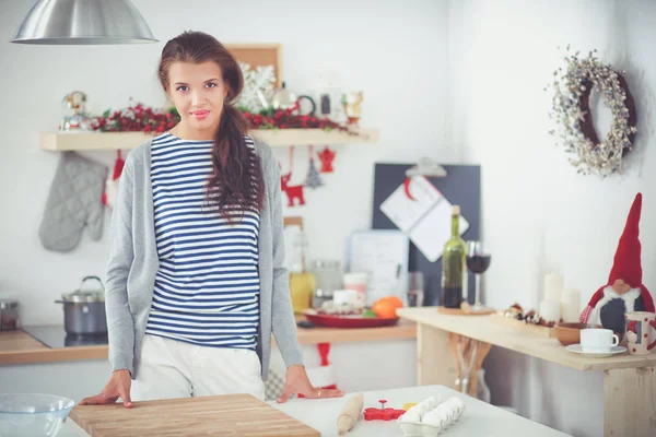 Portret van jonge vrouw tegen keuken interieur achtergrond — Stockfoto