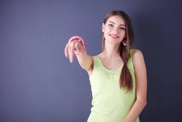 Joven hermosa mujer de pie cerca de la pared oscura —  Fotos de Stock