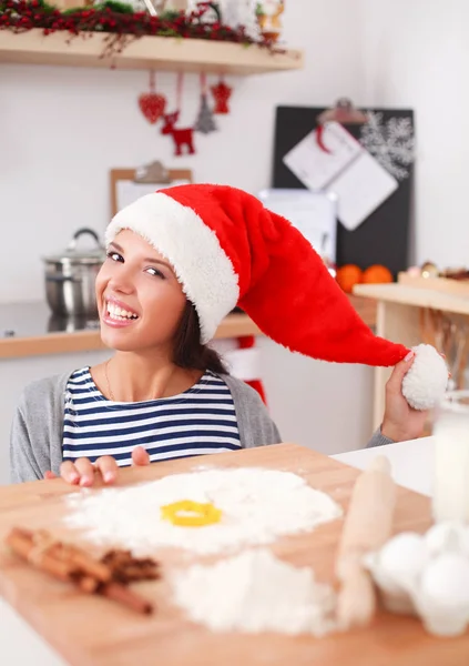 Женщина делает рождественское печенье на кухне — стоковое фото