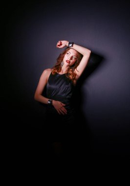 Siyah elbiseli, akşam makyajlı güzel bir kadın.