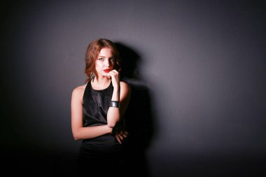 Siyah elbiseli, akşam makyajlı güzel bir kadın.