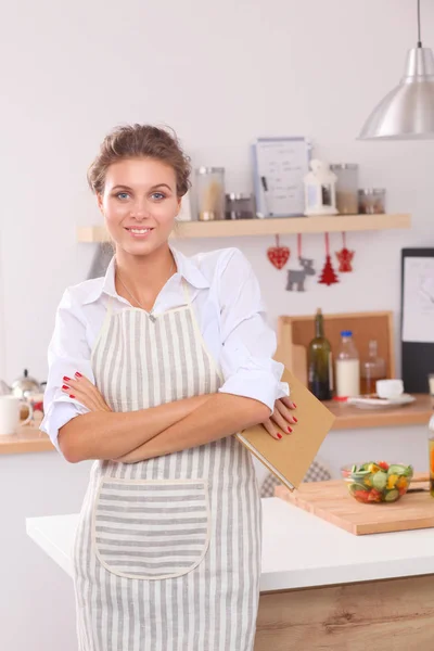 Mujer joven sonriente de pie en la cocina — Foto de Stock