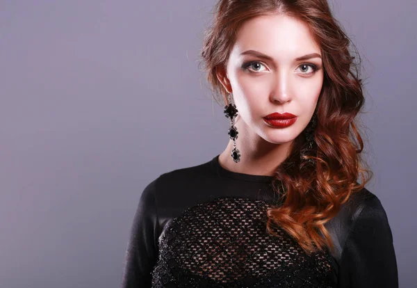 Siyah elbiseli, akşam makyajlı güzel bir kadın.