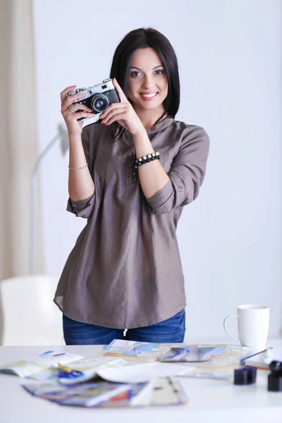 Retrato de una joven fotógrafa hermosa cerca de la mesa —  Fotos de Stock