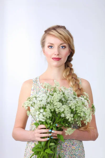 Menina sorridente bonita com flores em um fundo branco — Fotografia de Stock