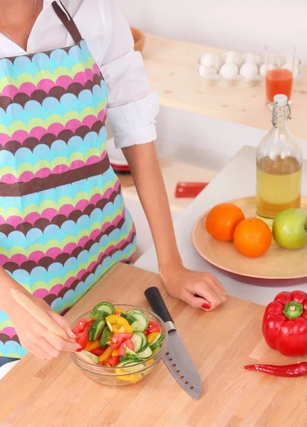 Giovane donna che taglia verdure in cucina — Foto Stock