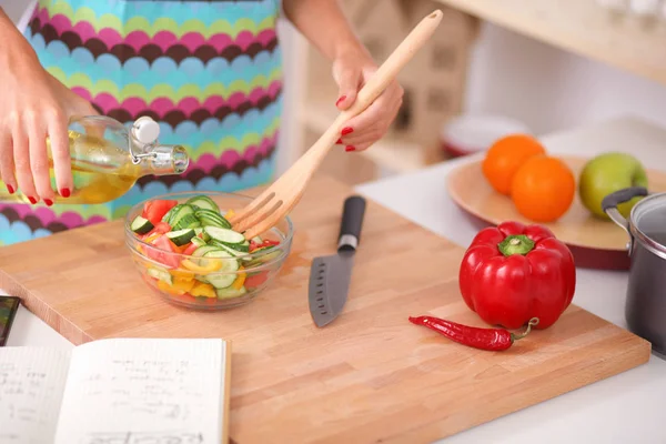 Mladá žena řezání zeleniny v kuchyni — Stock fotografie