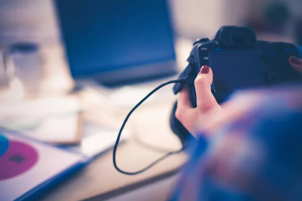 Female photographer sitting on the desk with laptop . Female photographer — Stock Photo, Image