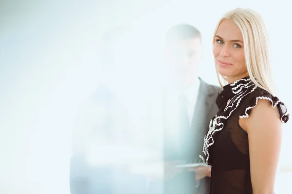 Zakenvrouw permanent op voorgrond in office . — Stockfoto