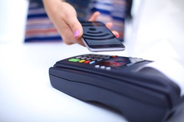 Müşteri ile smartphone Nfc teknolojisi kullanılarak dükkanda ödüyor. NFC teknolojisi. Müşteri ödeme