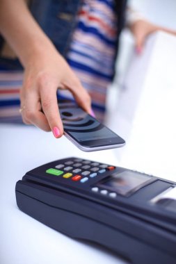 Müşteri ile smartphone Nfc teknolojisi kullanılarak dükkanda ödüyor. NFC teknolojisi. Müşteri ödeme