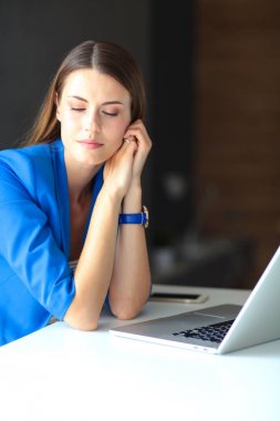 Elinde evrakları olan kadın masanın üstünde oturuyor.