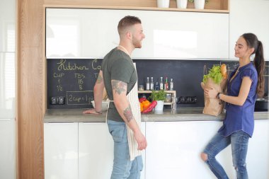 Güzel genç çift evde mutfakta eğleniyor.