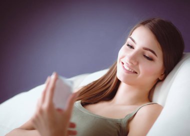 güzel bir kadın onun oturma odasında kanepede karışıklık gönderme yalan