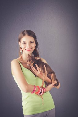 Gri arka plan üzerinde duran çekici genç kadın