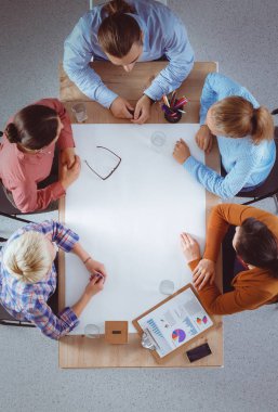 İş adamları iş toplantısında, ofiste oturup tartışıyorlar.