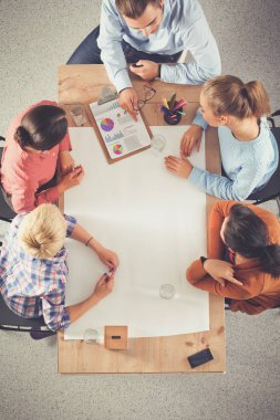 İş adamları iş toplantısında, ofiste oturup tartışıyorlar.