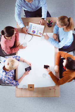 İş adamları iş toplantısında, ofiste oturup tartışıyorlar.