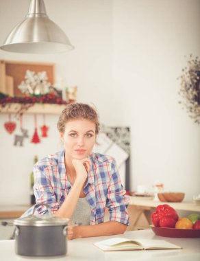 Mutfakta masada oturan genç bir kadın.