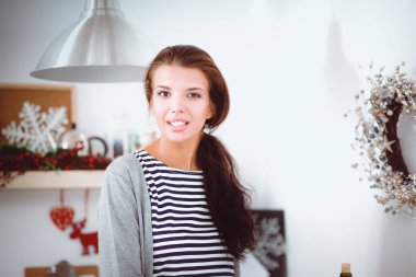 Genç bir kadının portresi mutfak arka planında.