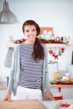 Genç bir kadının portresi mutfak arka planında.