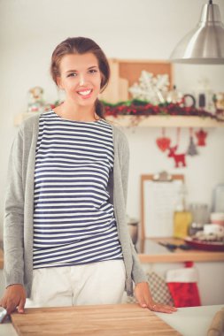 Elinde belgelerle masanın üstünde oturan gülümseyen kadın..