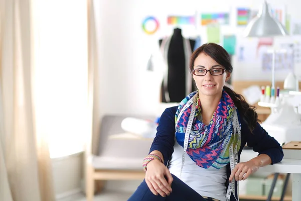 Hermoso diseñador de moda sentado en el escritorio en el estudio . —  Fotos de Stock