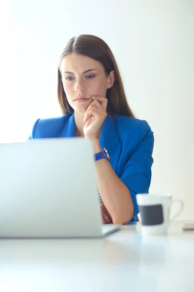 Portret van een jonge vrouw op telefoon achter een laptopcomputer — Stockfoto