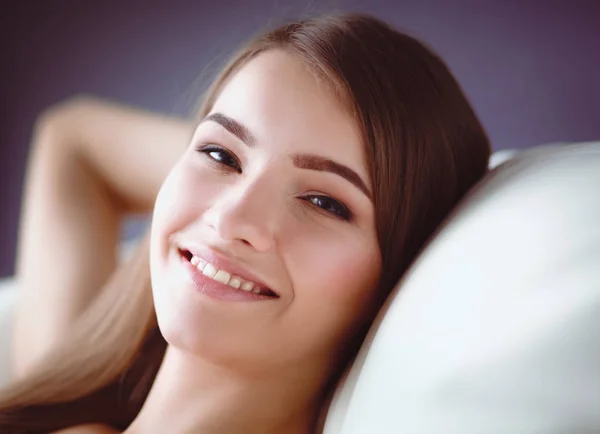 Fechar-se de uma jovem mulher sorridente deitada no sofá — Fotografia de Stock