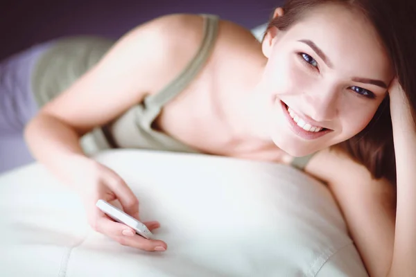 Mooie vrouw in haar woonkamer liggend op de bank verzenden puinhoop — Stockfoto