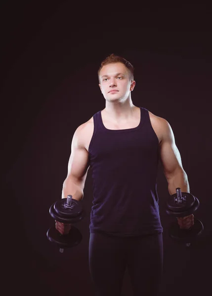 Schöner muskulöser Mann, der mit Hanteln trainiert — Stockfoto