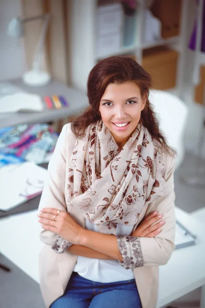 Sonriente diseñadora de moda sentada en el escritorio de la oficina — Foto de Stock