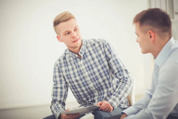 Zwei Kollegen diskutieren gemeinsam über ein Projekt oder eine Zusammenarbeit im hellen modernen Büro — Stockfoto