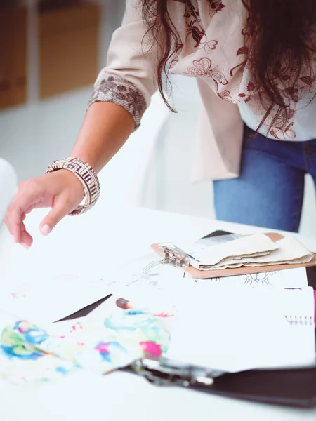 Usmívající se žena módní návrhářka sedí u psacího stolu — Stock fotografie