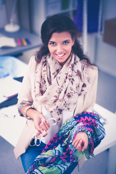 Sorrindo designer de moda feminina sentado na mesa de escritório — Fotografia de Stock